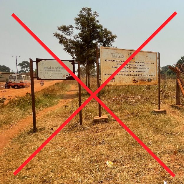 Weathered project sign with faded text and outdated partner logos