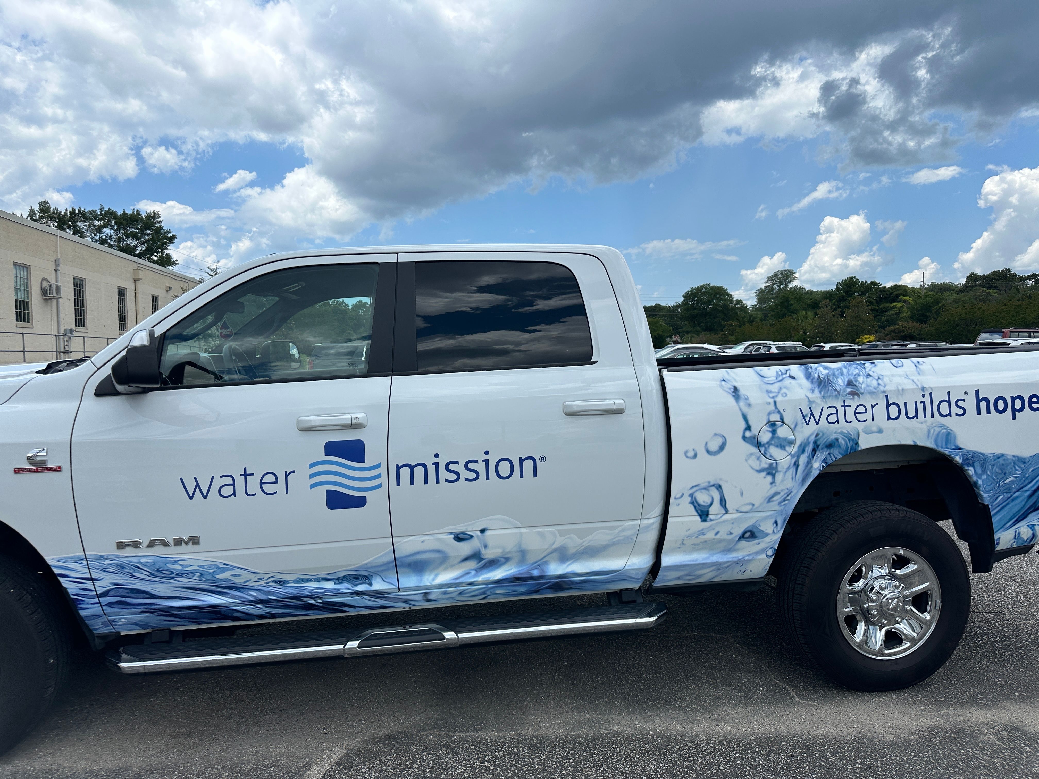 Water Mission wrapped white pickup side view