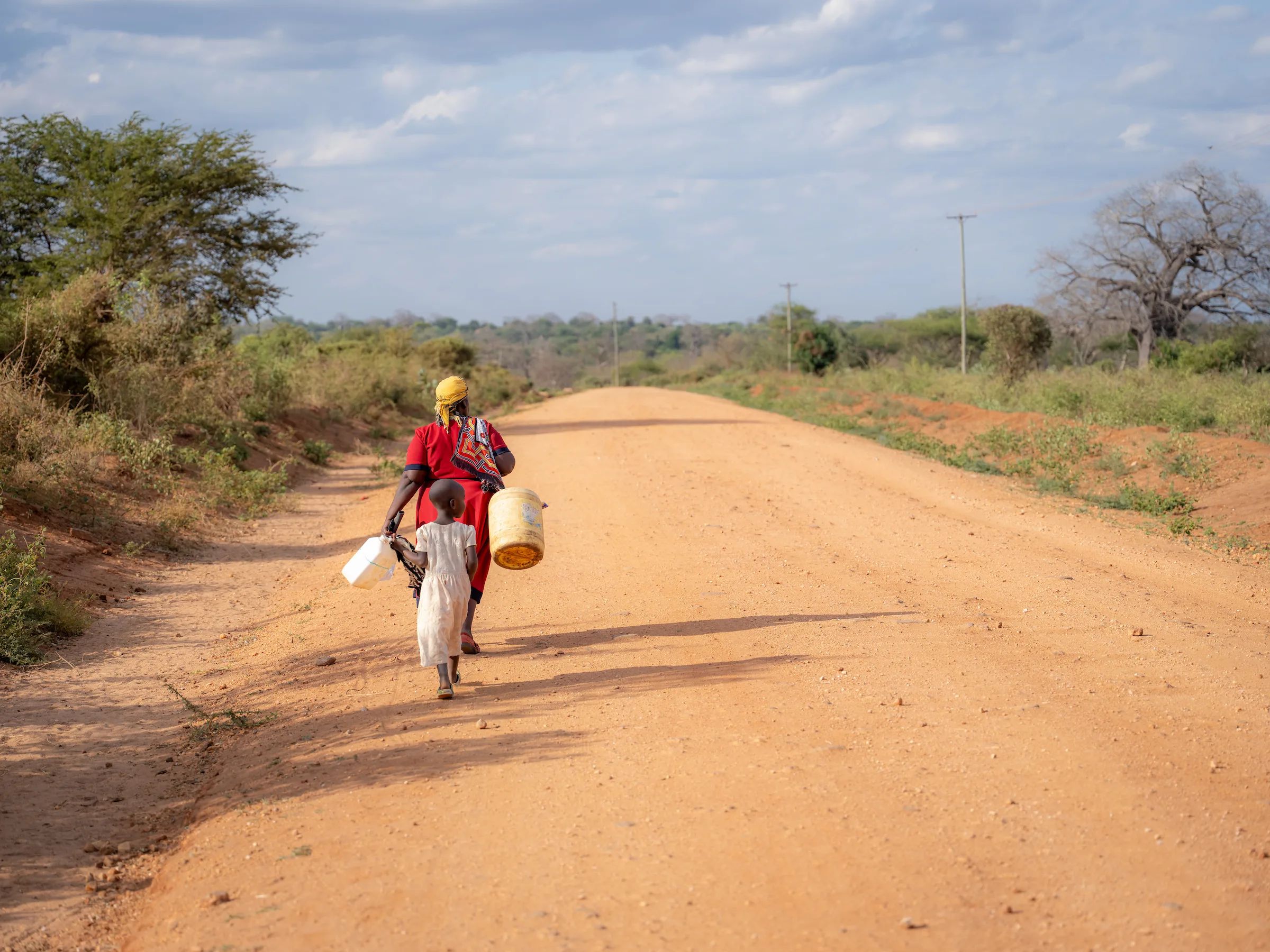 Mother and child walking with jerry can