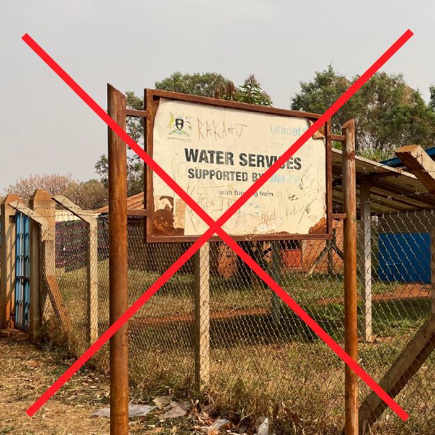 Temporary, low-quality project sign made from improvised materials that appear unprofessional